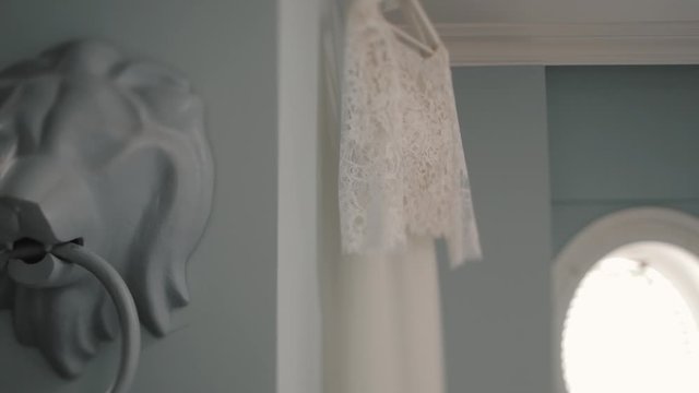 White lion statue with circle and wedding dress are hanging on the wall, white walls, minimalism interior