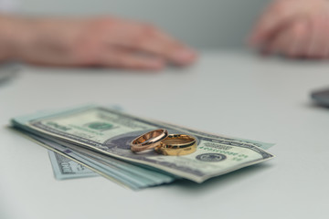 Divorce property. Money and wedding rings on the table