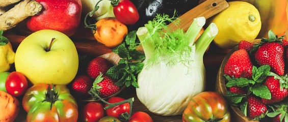 full frame of a rustic composition of fruit and vegetables arranged on a table