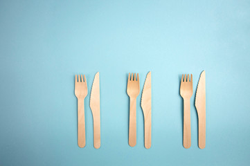 Eco-friendly disposable utensils made of bamboo wood and paper on a blue background. look from above. ecology, zero waste concept. top view. flat lay.