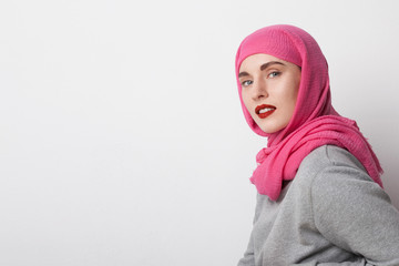 Close-up portrait of a muslim woman wearing a head scarf hijab and smilling. Isolated. Space for text.