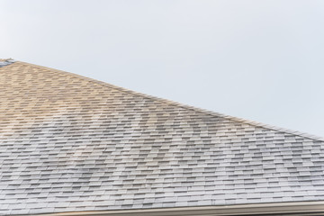 Morning light and frost on black shingle roof of residential house under clear blue sky near Dallas, Texas, USA