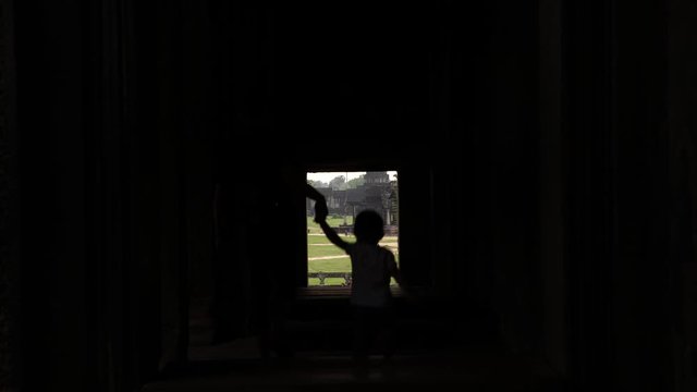 Madre e hijo entrando por una ventana al templo principal de Angkor Wat