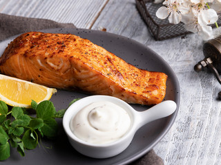 roasted baked salmon fillet with lemon, white sauce and pea sprouts healthy food