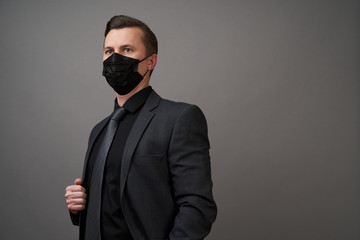 Young businessman with surgical medical mask, close-up portrait