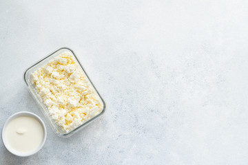  Curd and cheese dumplings served with berries and sour cream on a ceramic white plate. Traditional Ukrainian or Russian lazy dumplings (vareniki). Healthy Breakfast, top view.
