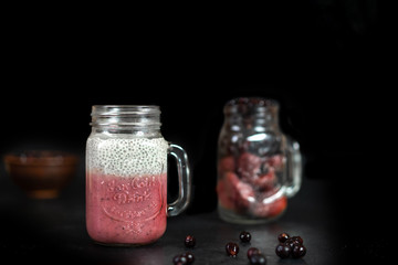 Summer berry cocktail with chia seeds in vegetable milk in glass glasses on a dark background.
