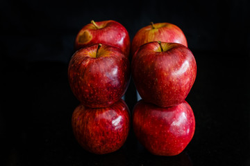 Fototapeta na wymiar Varias manzanas apiladas y humedad con fondo negro