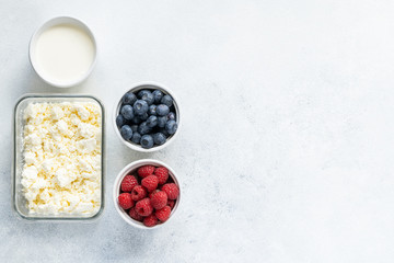  Curd and cheese dumplings served with berries and sour cream on a ceramic white plate. Traditional Ukrainian or Russian lazy dumplings (vareniki). Healthy Breakfast, top view.