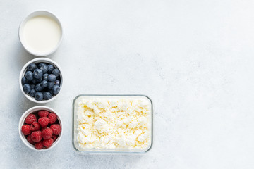  Curd and cheese dumplings served with berries and sour cream on a ceramic white plate. Traditional Ukrainian or Russian lazy dumplings (vareniki). Healthy Breakfast, top view.