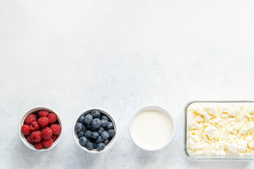  Curd and cheese dumplings served with berries and sour cream on a ceramic white plate. Traditional Ukrainian or Russian lazy dumplings (vareniki). Healthy Breakfast, top view.