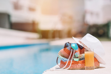 Colorful beach bag, glass of juice, straw hat and airplane model