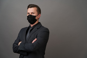 Fototapeta premium Young businessman with surgical medical mask, close-up portrait