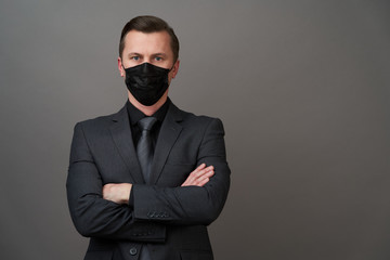 Young businessman with surgical medical mask, close-up portrait