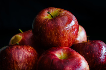 Varias manzanas apiladas y humedad con fondo negro