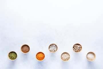 Dry bio cereals in craft bio cups made of paper on a gray background. Concept of healthy food with home delivery. Top view, Copy space.