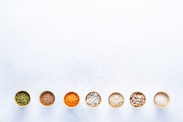 Dry bio cereals in craft bio cups made of paper on a gray background. Concept of healthy food with home delivery. Top view, Copy space.