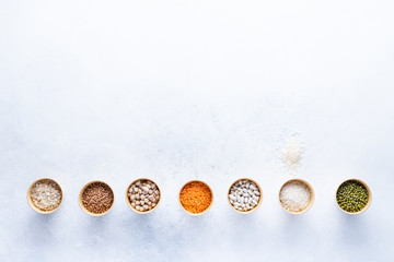 Dry bio cereals in craft bio cups made of paper on a gray background. Concept of healthy food with home delivery. Top view, Copy space.