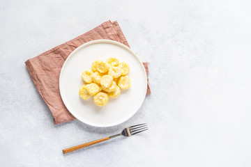  Curd and cheese dumplings served with berries and sour cream on a ceramic white plate. Traditional Ukrainian or Russian lazy dumplings (vareniki). Healthy Breakfast, top view.