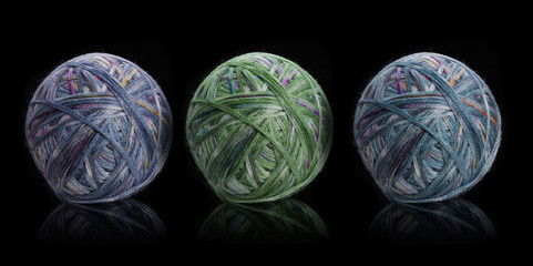 A ball of thread for knitting and on a knitting machine on a black background, needlework, knitting.