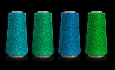 Yarn for knitting on bobbins, bobbin yarn on a black background. Knitting, machine knitting.