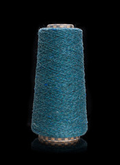 Yarn for knitting on bobbins, bobbin yarn on a black background. Knitting, machine knitting.