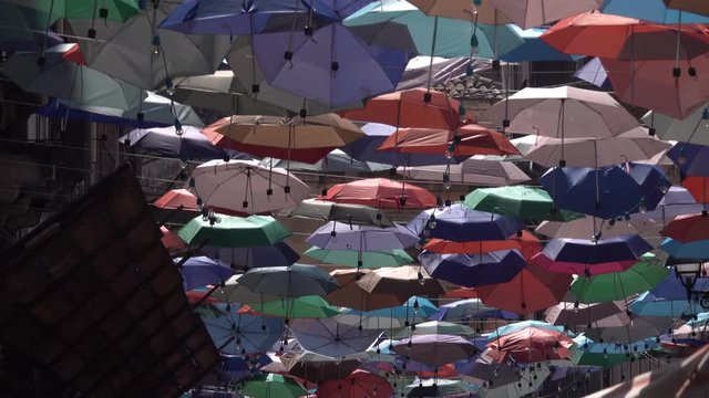 Colourful umbrellas are hanging on the rope between buildings, Catania, new airport of Istanbul