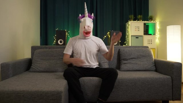 the man in the mask of the unicorn hits himself in the face