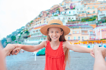 Adorable little girl on warm and sunny summer day in Positano town in Italy