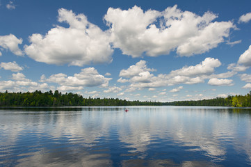 Lake view from a cottage dock in Algonquin Park, Ontario. Clouds are reflecting on the water while...