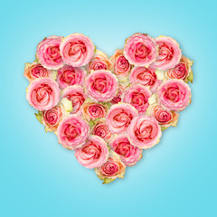 Bouquet of tea roses in the shape of a heart on a blue background. Valentine's Day.