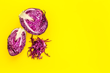 Red cabbage - cut head and sliced - on yellow desk from above copy space