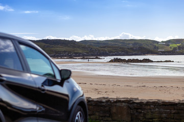 Fototapeta na wymiar Fintra Beach. Ireland April 2019. black car parked in front of a beautiful empty beach in county donegal.