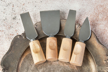 Old cheese knives on vintage metal dish