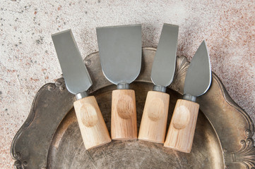 Old cheese knives on vintage metal dish