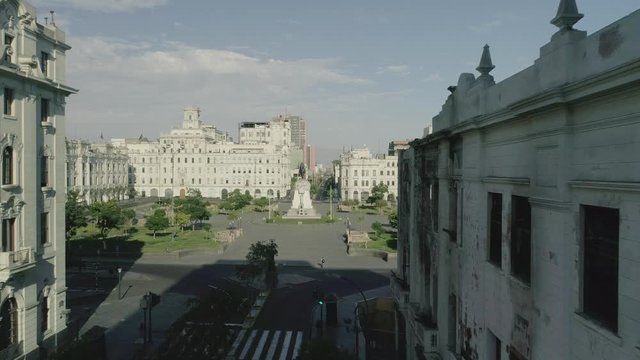 Dolly in with drone from avenida la colmena, between buildings to plaza San Martin.