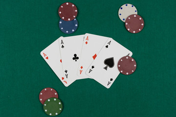 Winning hand in poker game with ace poker hand on green background and chips around