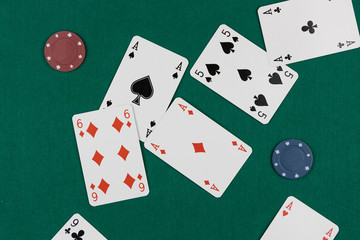 Scrambled poker cards and chips over a green background