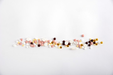 pills are on a white background, medicines of different colors are located along the length of the frame