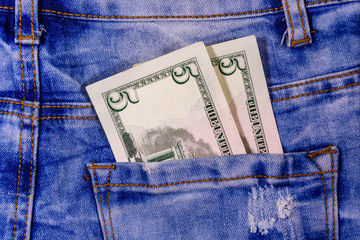 American five dollar banknotes in a pocket of blue jeans