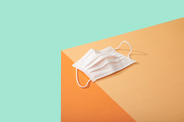 
Corona Virus Covid 19 White particle face mask lined up on edge of table surface
Mask on edge of table surface  bright bold colors