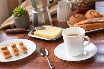 Breakfast with white crockery, coffee, cheese rolls, bread and milk