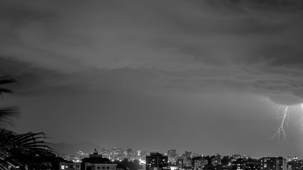 Imagens da chegada de uma tempestade de verão com raios e chuva, na cidade durante a noite em...