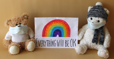 Soft toys bears in protective face mask next to a sheet of paper with rainbow and phrase "Everything will be OK". Kindergartens and schools are under quarantine due to epidemic of coronavirus COVID-19
