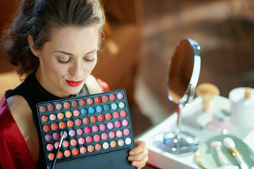 housewife with lip palette in modern living room in sunny day