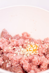Raw minced meat with smashed eggs and chopped onion mixture for meatballs. Copy space with homemade food concept