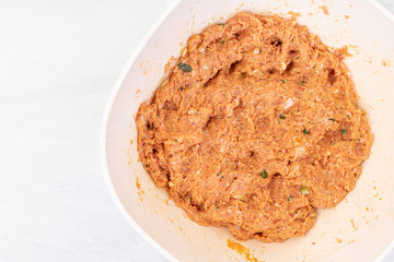 Raw minced meat mixture for meatballs in the bowl with copy space