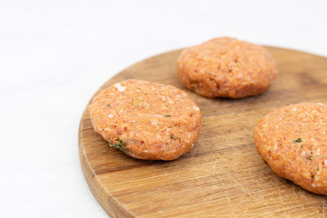 Fototapeta na wymiar Raw minced meat meatballs on the wooden board ready for frying