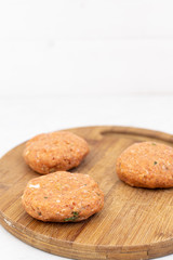 Raw minced meat meatballs on the wooden board ready for frying with copy space above