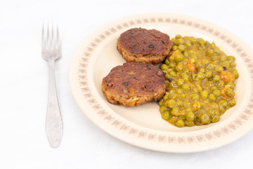 Served fried meatballs with cooked peas on the plate